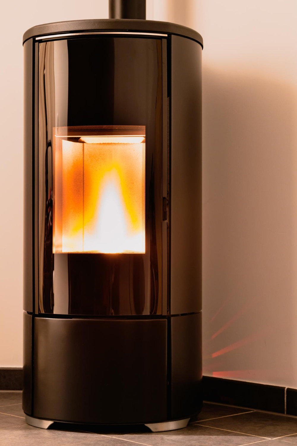 Poêle à granulés moderne en fonctionnement Poêle à granulés noir allumé dans une pièce, produisant une flamme vive et chaleureuse